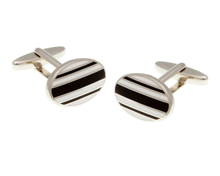 Silver cufflinks with black stripes on a white background