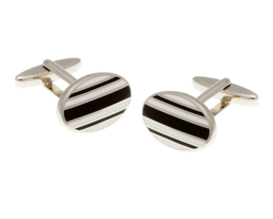 Silver cufflinks with black stripes on a white background