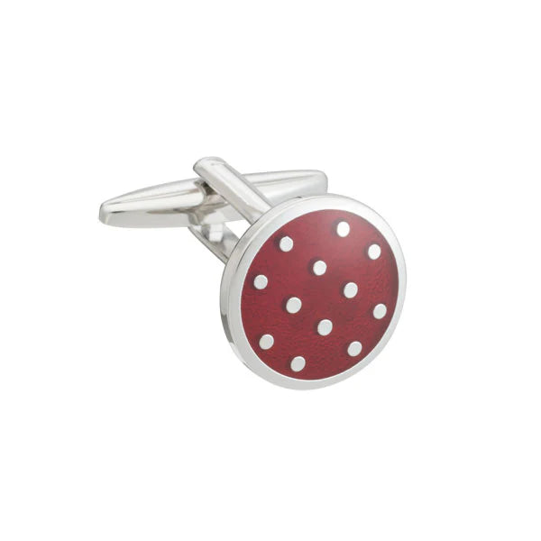Cufflink with red circular design and white polka dots on a white background