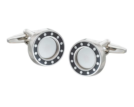 Silver cufflink with black and white design on a white background