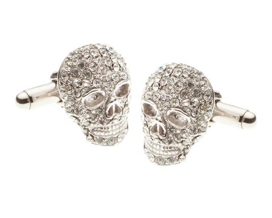 Skull-shaped cufflinks with gemstones on a white background