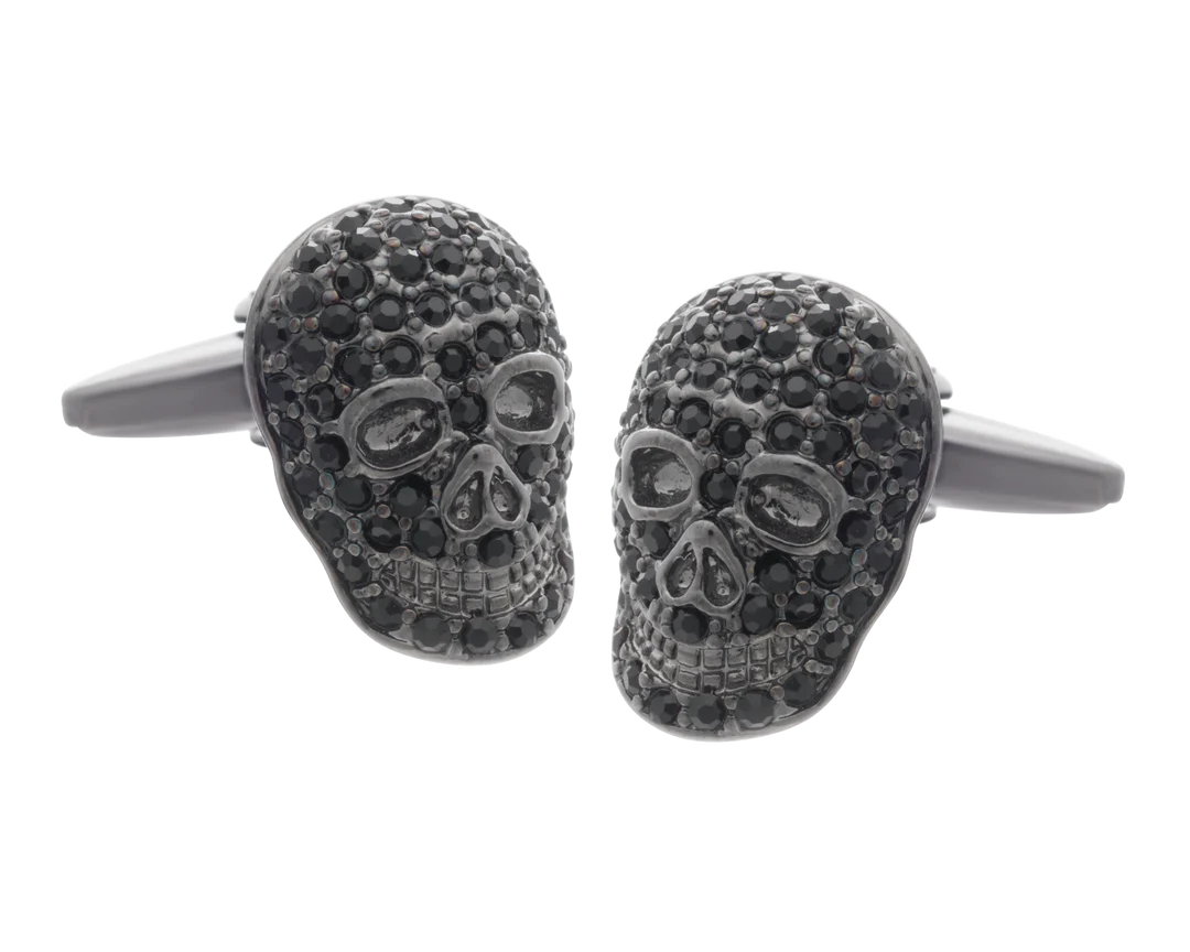 Skull-shaped cufflinks with black gemstones on a white background