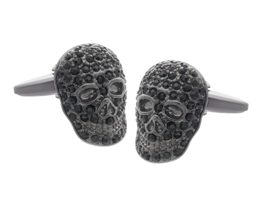 Skull-shaped cufflinks with black gemstones on a white background
