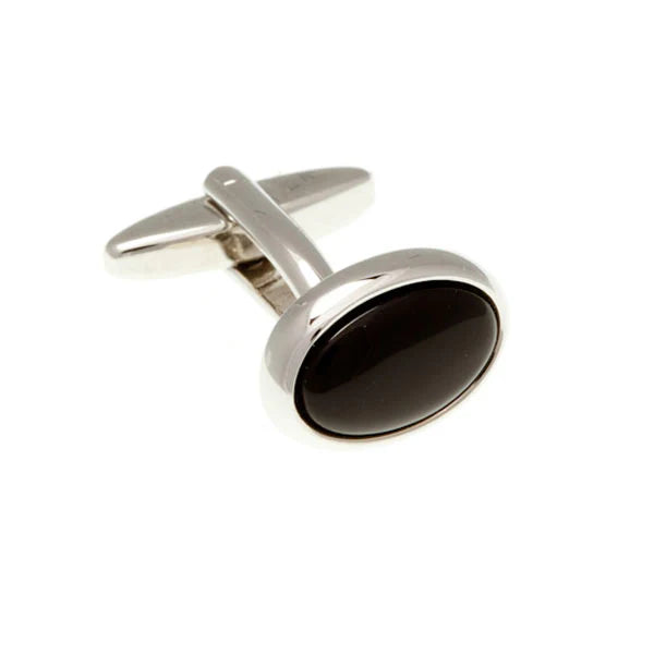 Silver cufflink with a black stone on a white background