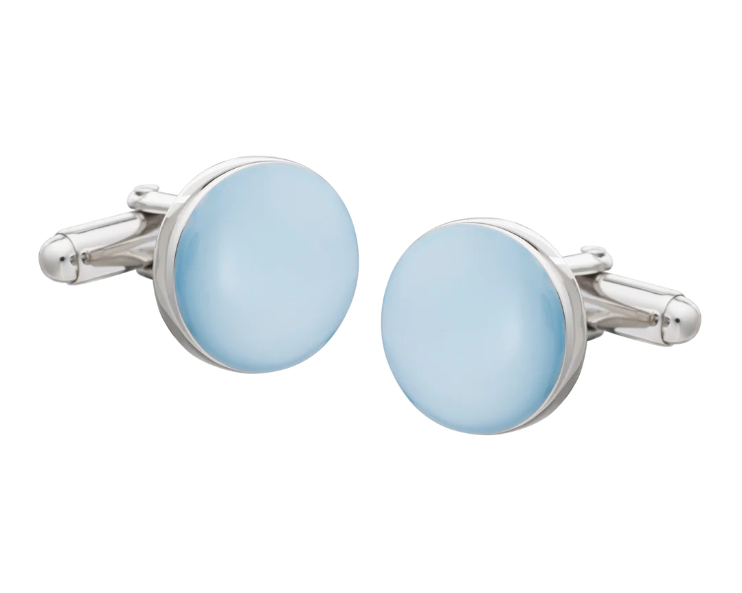 Cufflinks with light blue circular stones and silver metal frames on a white background