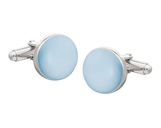 Cufflinks with light blue circular stones and silver metal frames on a white background