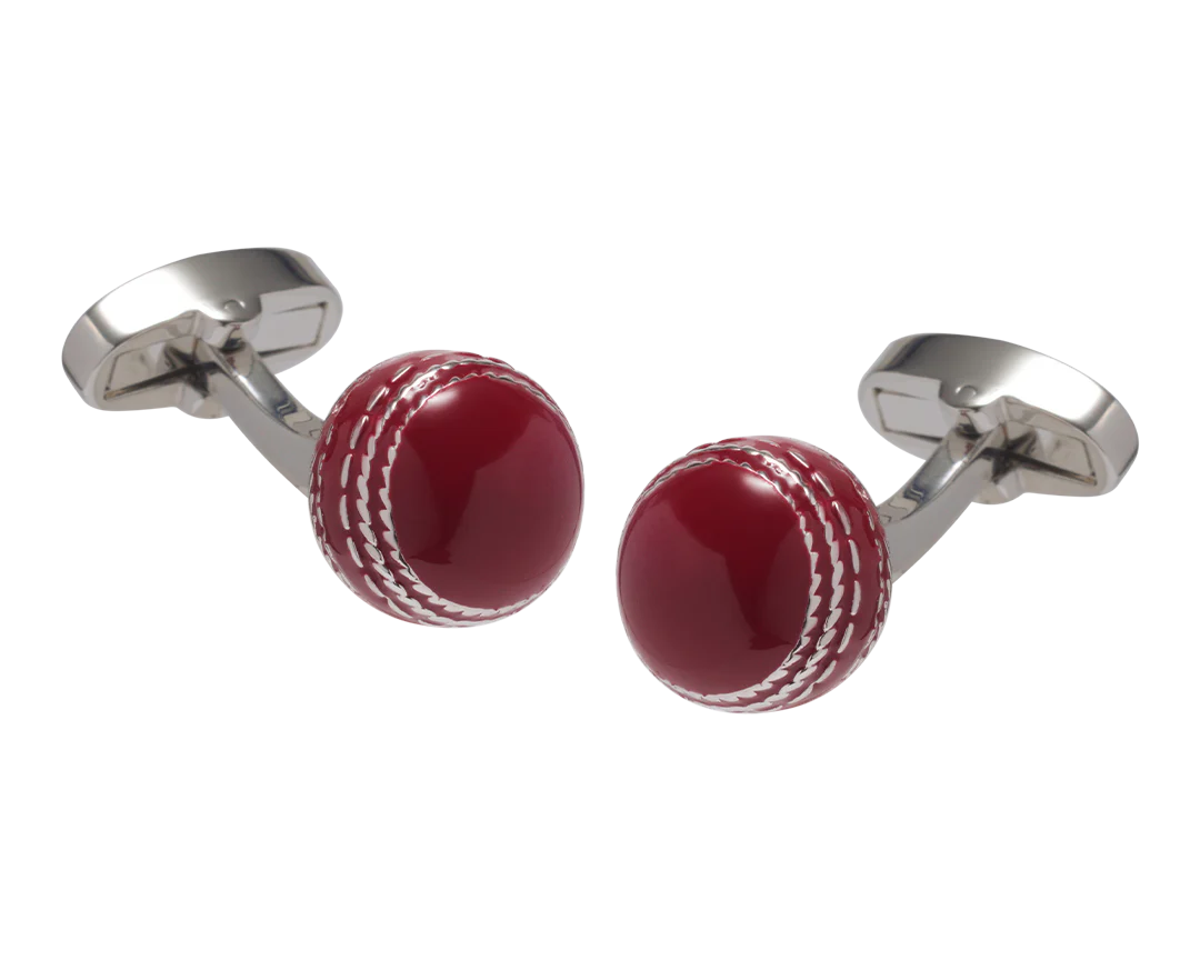 Cufflinks designed like a red cricket ball with silver metal loops on a white background