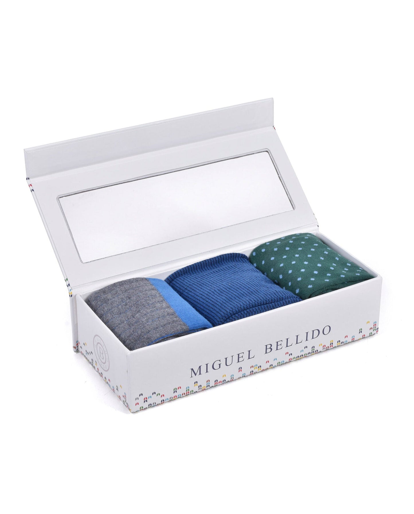 Three pairs of socks in a box with 'Miguel Bellido' branding on a white background
