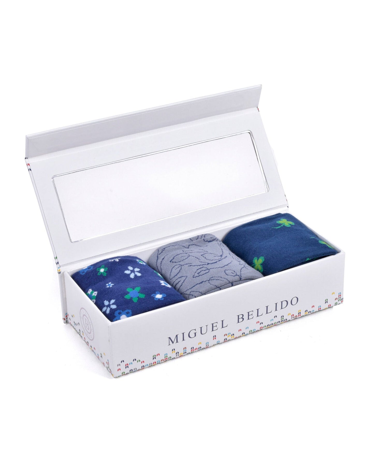 Three pairs of socks in a box with 'Miguel Bellido' branding on a white background
