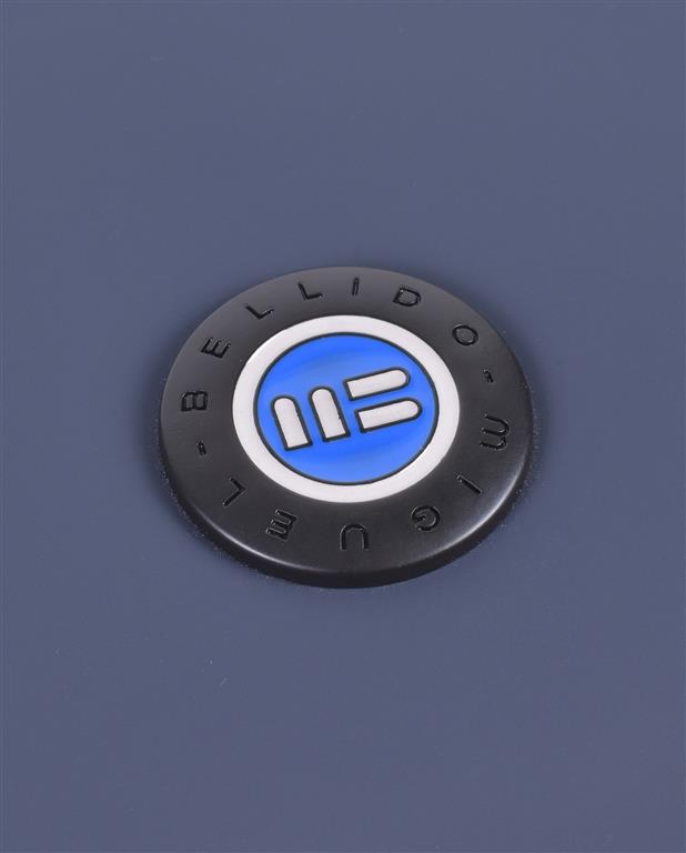 Round black badge with a blue and white logo on a blue background
