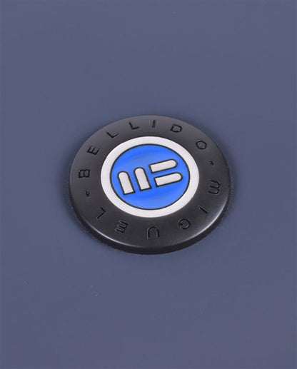 Round black badge with a blue and white logo on a blue background
