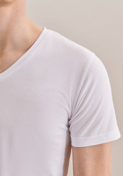 White t-shirt worn by a person on a plain background