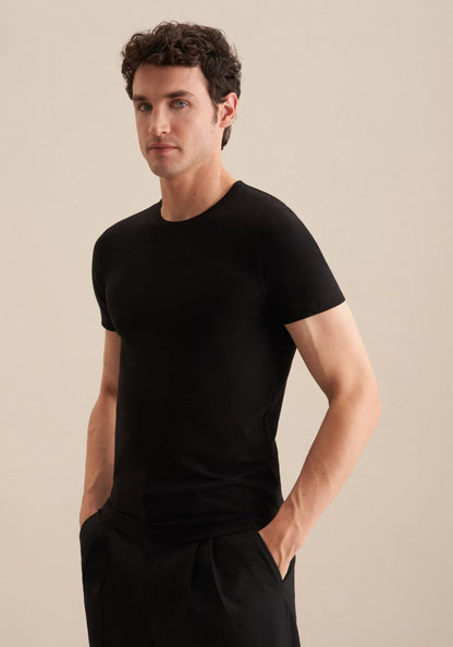 Man wearing a black t-shirt against a beige background