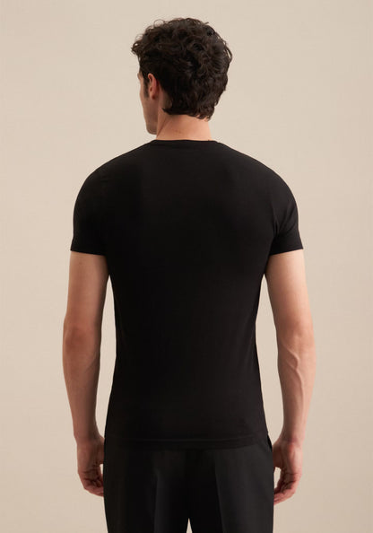 Man wearing a black t-shirt against a beige background