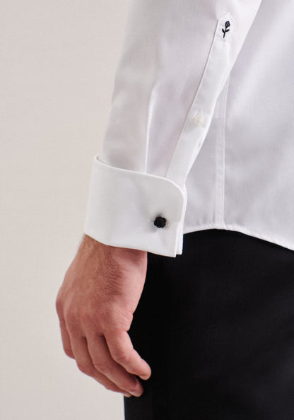 Close-up of a white shirt with black buttons and cufflinks on a plain background