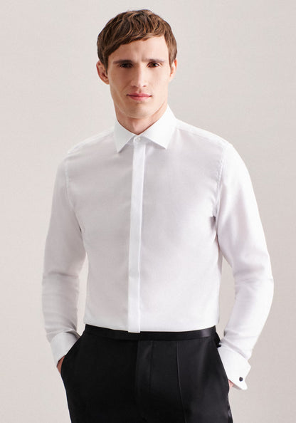 Man wearing a white dress shirt and black pants against a plain background