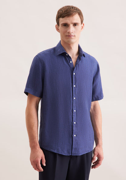 Man wearing a blue short-sleeve shirt against a plain background