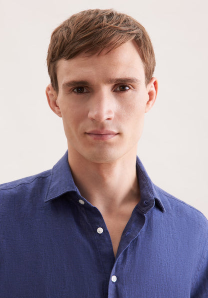 Man wearing a blue shirt against a plain background