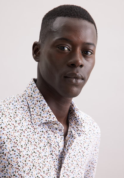 Man wearing a patterned shirt against a plain background