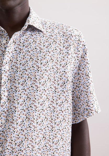 Close-up of a person wearing a short-sleeve shirt with a subtle pattern on a plain background
