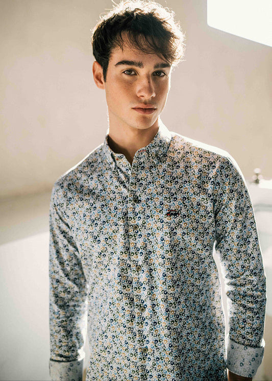 Man wearing a patterned shirt in a neutral setting