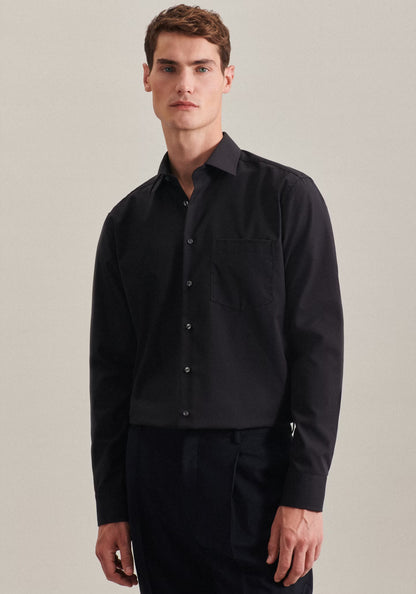 Man wearing a black shirt against a plain background