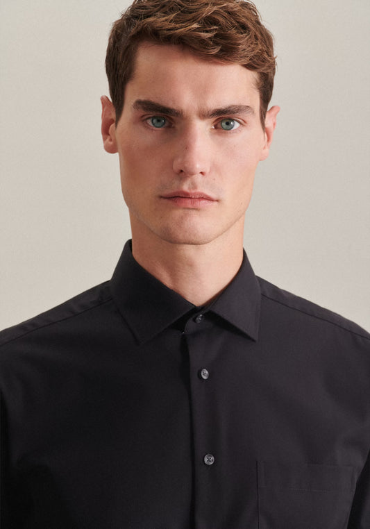 Man wearing a black dress shirt against a plain background