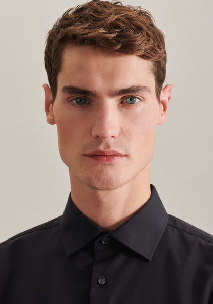 Man wearing a black shirt against a plain background