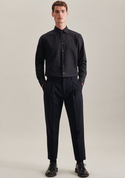 Man wearing a black shirt and pants on a plain background