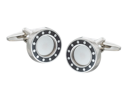 Silver cufflink with black and white design on a white background