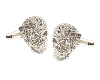 Skull-shaped cufflinks with gemstones on a white background