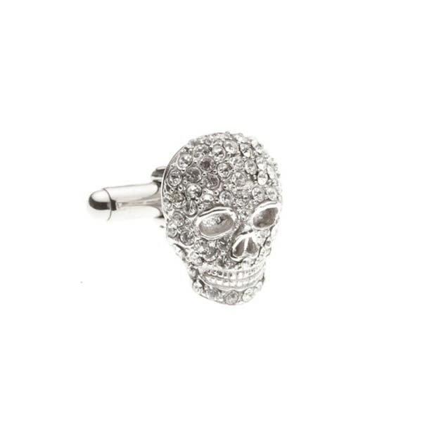 Silver skull-shaped cufflink with gemstones on a white background