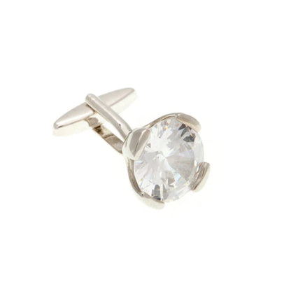 Silver cufflink with a clear gemstone on a white background