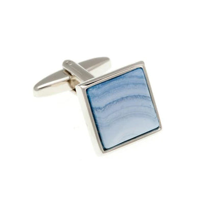 Cufflink with blue stone inlay on a white background