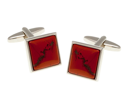 Square cufflinks with red stone and silver frame on a white background