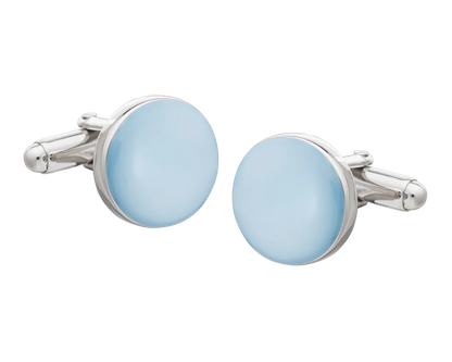 Cufflinks with light blue circular stones and silver metal frames on a white background