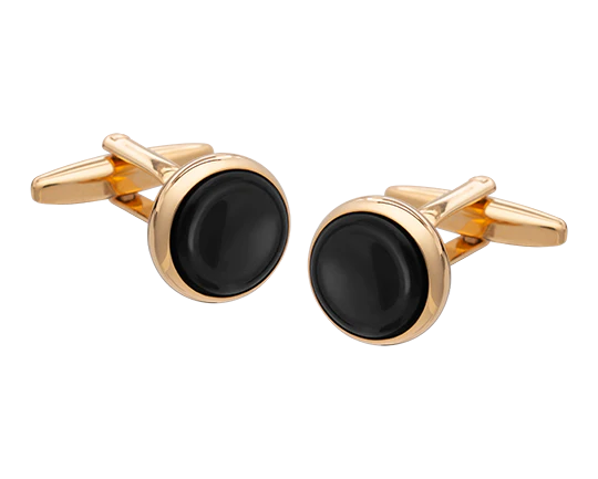 Gold cufflinks with black stones on a white background