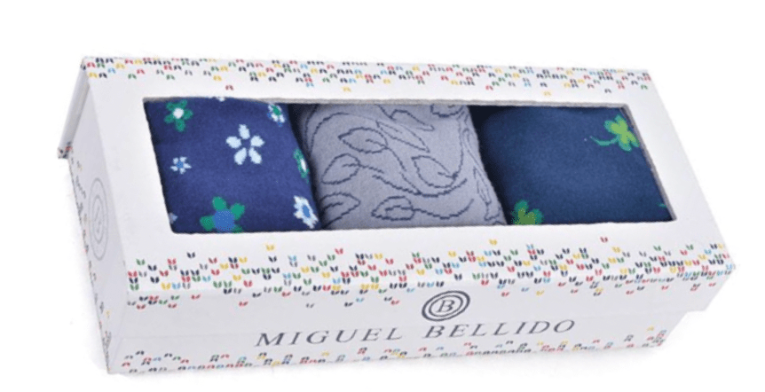 Box of mens socks with floral and animal patterns, branded 'Miguel Bellido'.