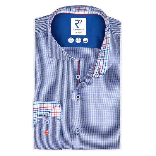 Folded blue checkered shirt with R2 branding on a white background