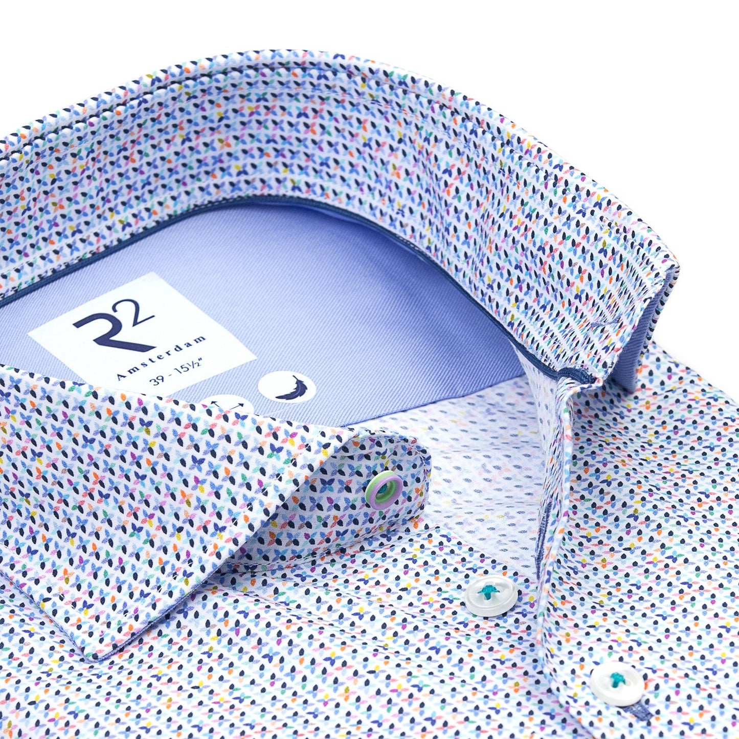 Close-up of a patterned shirt with a collar and cuff, featuring a brand label.