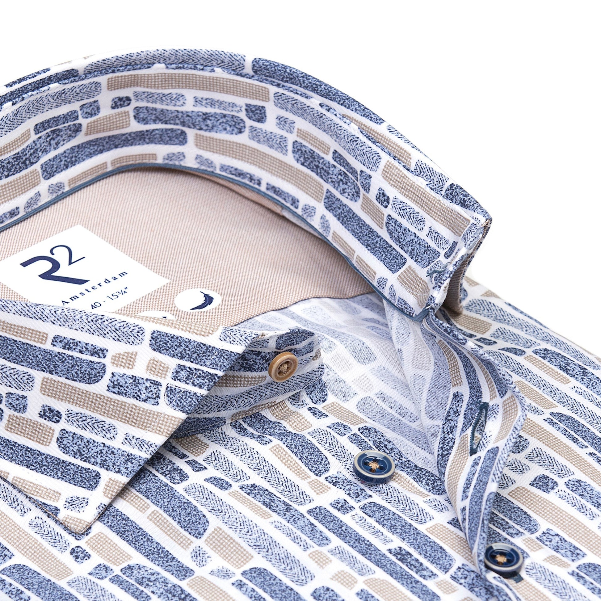 Close-up of a patterned shirt with collar and buttons, featuring a brand label.
