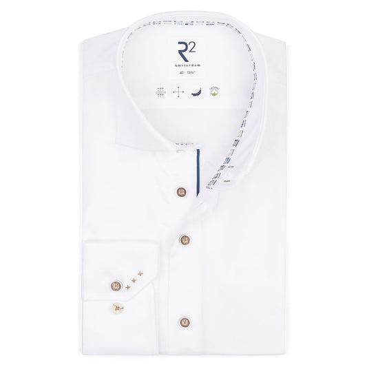 White dress shirt with decorative buttons and embroidery on a white background