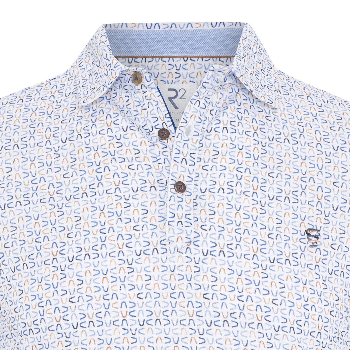 Close-up of a patterned shirt with a brand logo on a white background