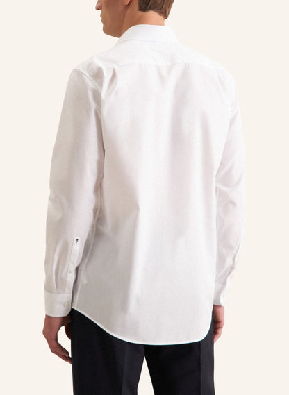 Person wearing a white dress shirt on a plain background