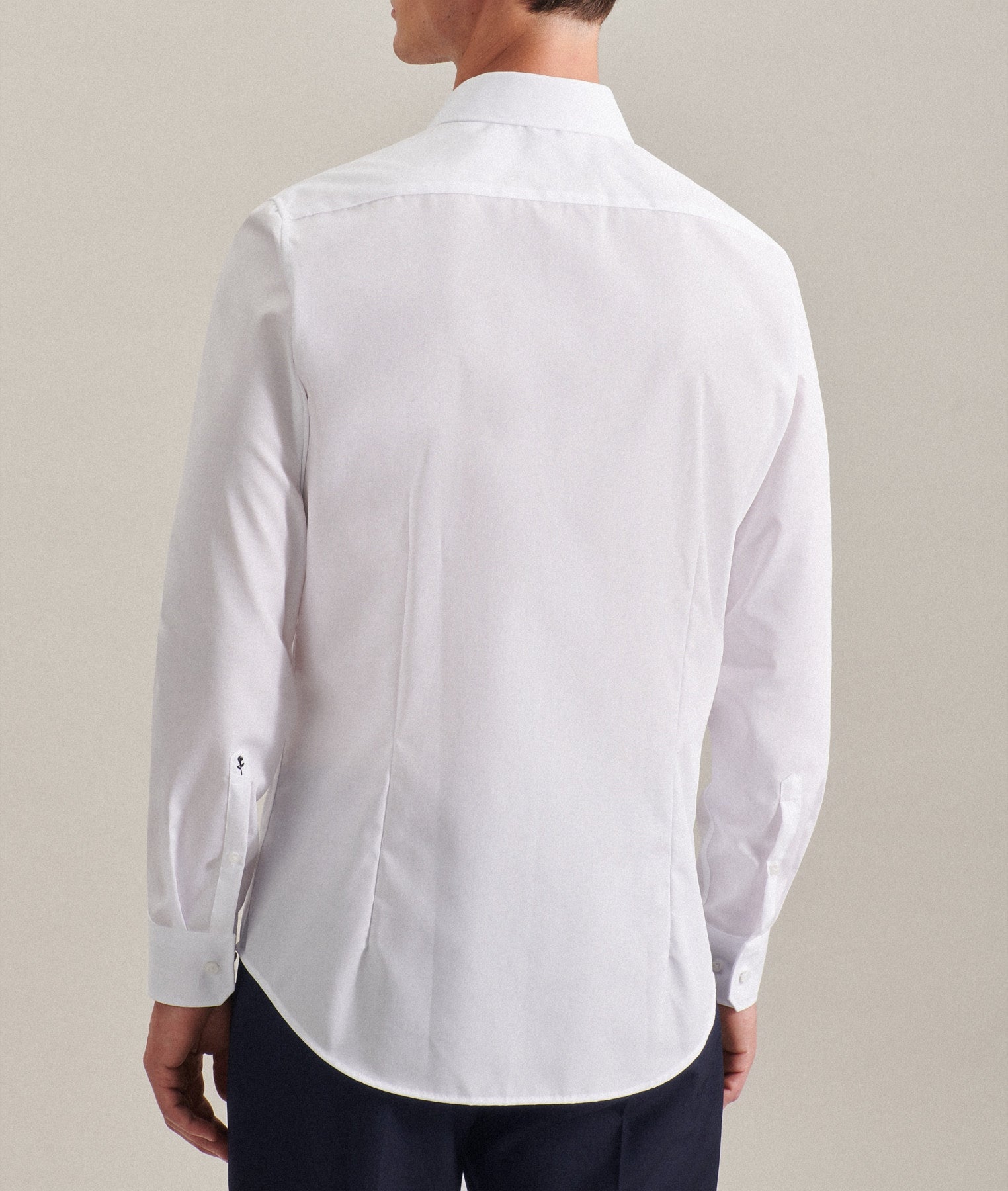 White shirt worn by a person on a beige background