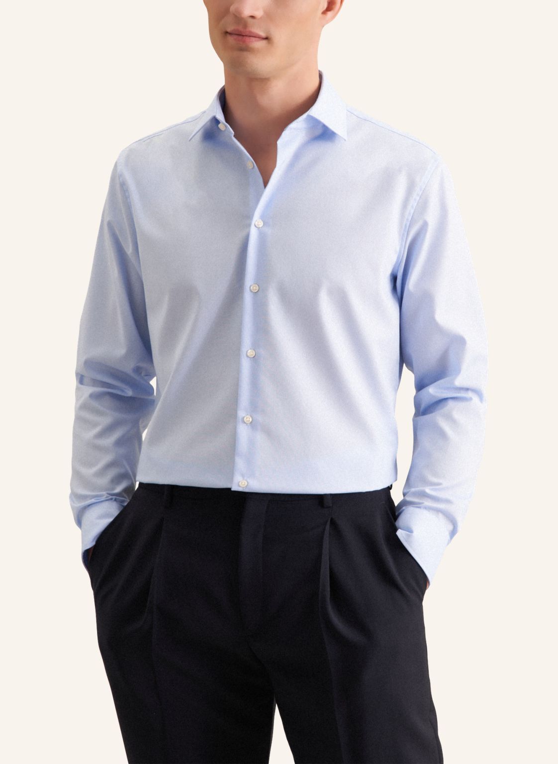 Light blue dress shirt with black pants on a plain background