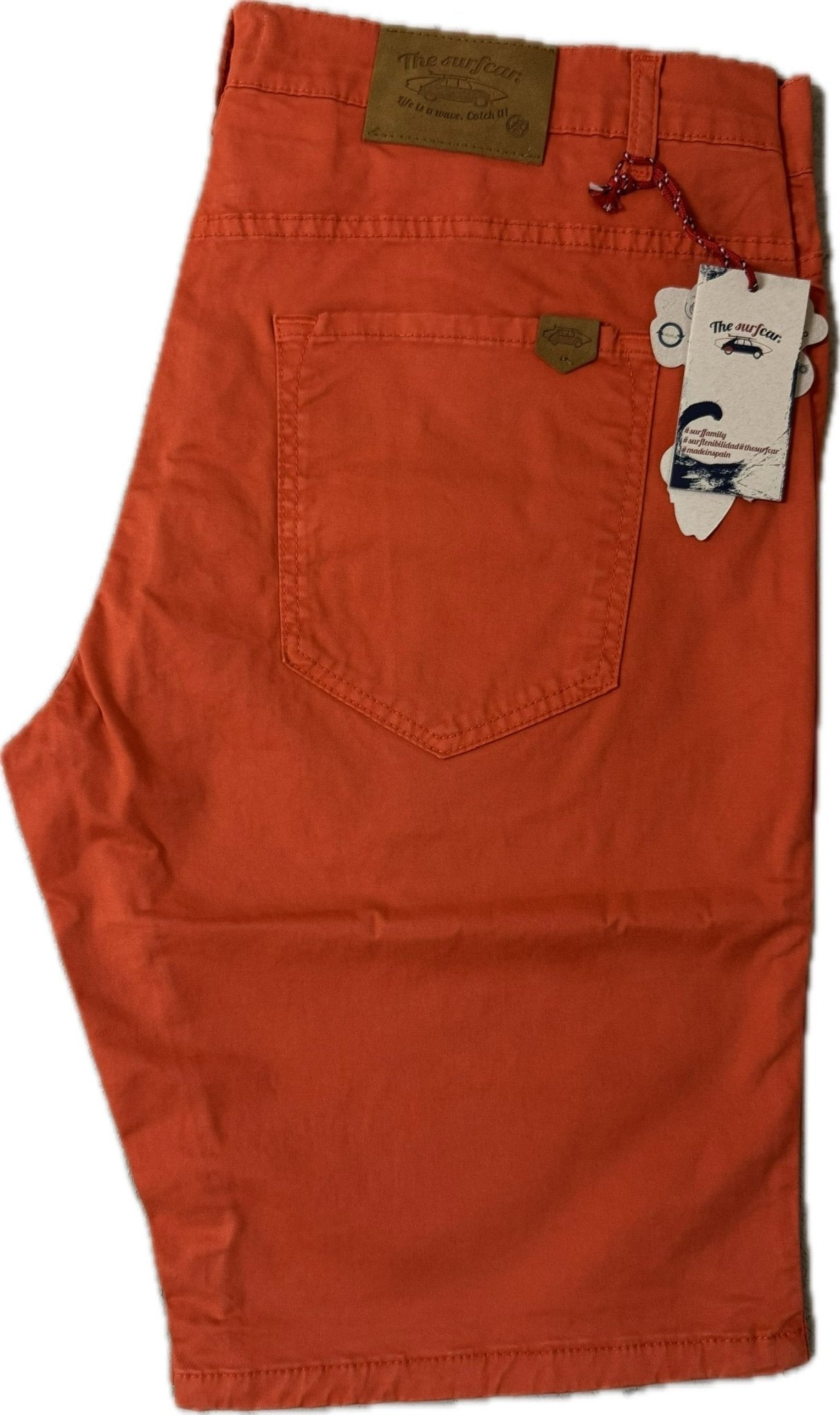 Orange pants with a tag on a white background