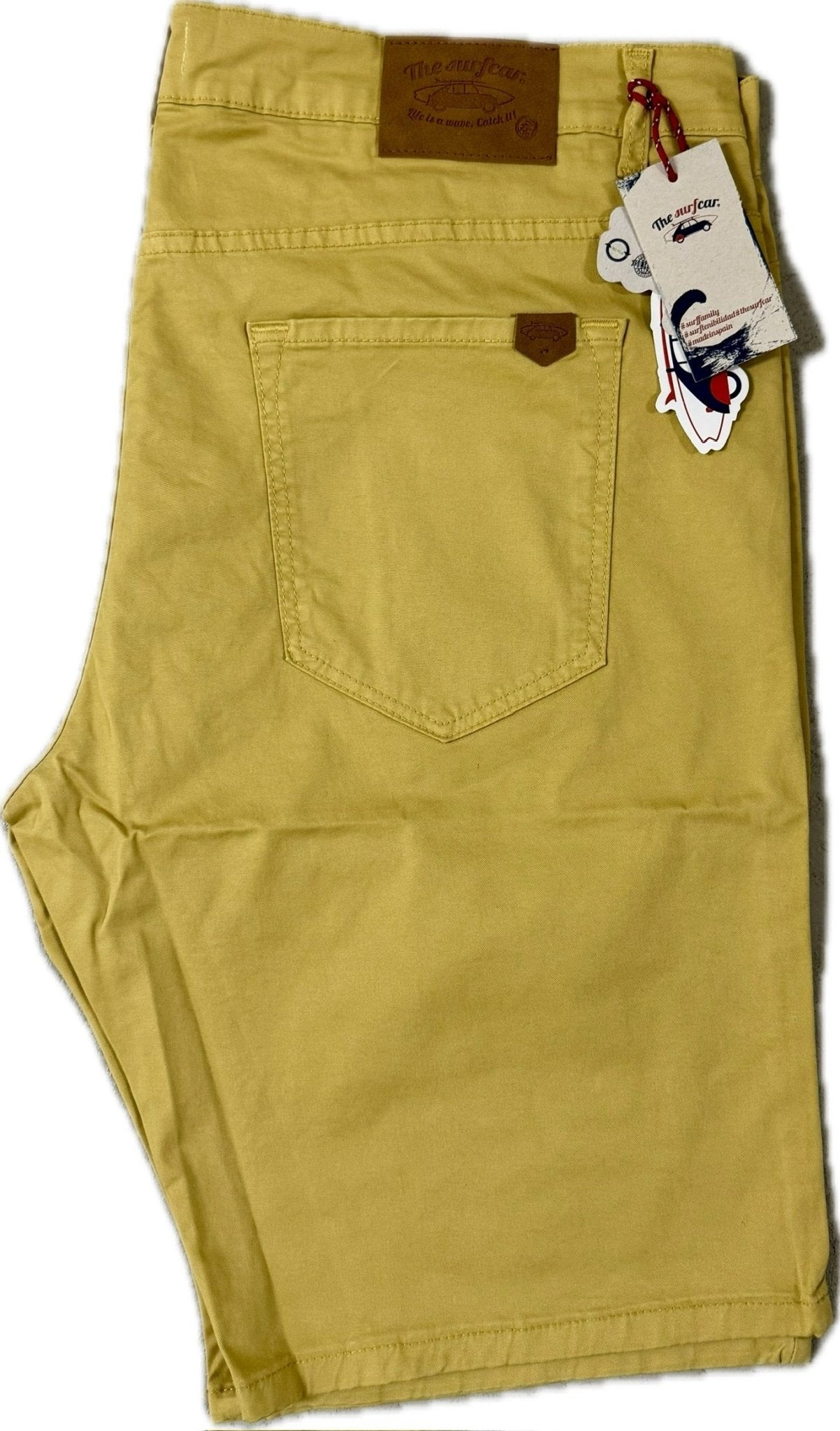 Yellow shorts with a tag on a white background
