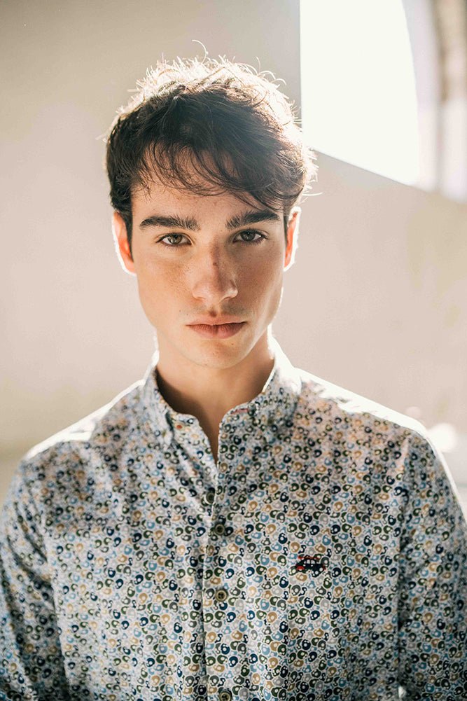 Man wearing a patterned shirt with a blurred background