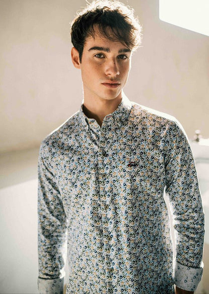 Man wearing a patterned shirt in a softly lit room
